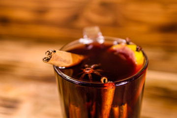 Cup of mulled wine with cinnamon on wooden table
