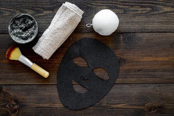 Black facial mask. Black head remover mask. Mask with clay on dark wooden background top view copy space