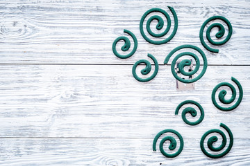 Mosquito repellent for outdoor: garden, summer house, picnic. Green spiral on grey wooden...