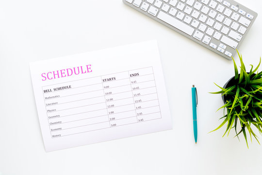 School student's schedule with time of lessons on white office desk with computer keyboard top view copy space