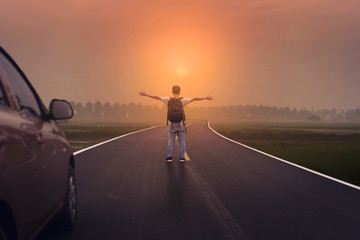 Naklejka na ściany i meble Freedom and Spiration of Life. A man standing on the road with Sunset scene.