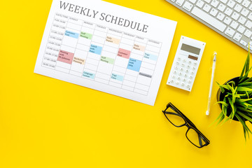 Weekly schedule. Planning the week. Multicolored planner on manager, marketologist's yellow office...