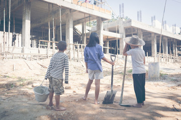 Little children working in commercial building structure, World Day Against Child Labour concept.