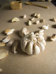 Fresh Garlic Bulb and Garlic Cloves on the MDF wooden plate board Texture Background