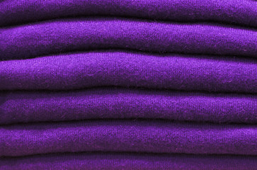Fototapeta na wymiar Stack of trend Ultra Violet woolen sweaters close-up, texture, background
