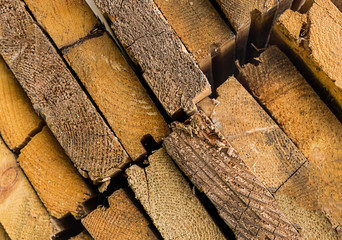 set of light beige boards close-up part of a stack of diagonal row texture dried wood with a crack...