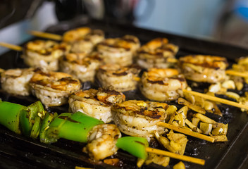 fried shrimp grilled on skewers purified flavored green chili pepper and garlic acute pikatnye garnish on gridiron background