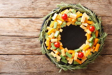 Assorted pesto cheese, cheddar, Mimolette with tomatoes and rosemary in the form of a wreath...