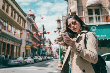 girl standing and using her phone in chinatown
