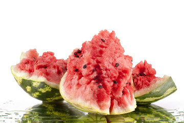 Watermelon pieces on white mirror background in water drops isolated close up