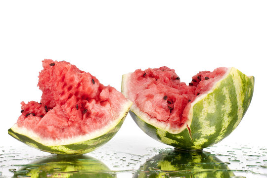 Pieces of watermelon on white mirror background in water drops isolated close up