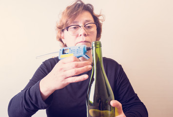 Woman decorating a bottle from wine with an ecological twine. Rustic style, handmade craft. Gift for christmas and other celebrations. Crafting process. Selective focus