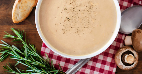 Mushroom cream soup with herbs and spices. Homemade, country style chanterelle Cream-soup on wooden table.