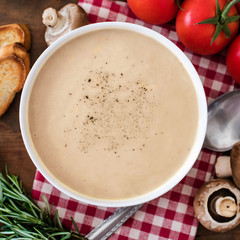 Mushroom cream soup with herbs and spices. Homemade, country style chanterelle Cream-soup on wooden table.