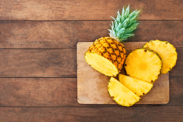 Pineapple on wood texture background. Whole and sliced tropical pineapple on wooden cutting board  with copy space. Top view. - Powered by Adobe