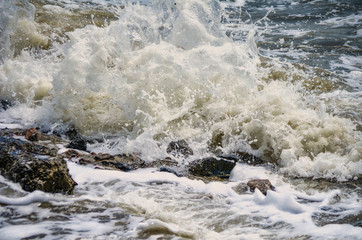 Powerful Waves crushing on a rocky beach.Powerful waves of the sea foaming, breaking against the rocky shore