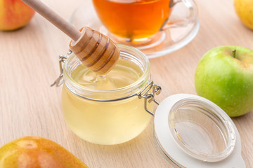 Jewish holiday Rosh Hashanah background with honey and apples on wooden table.