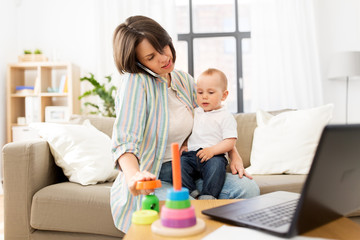 multi-tasking, freelance and motherhood concept - working mother with baby son calling on smartphone at home