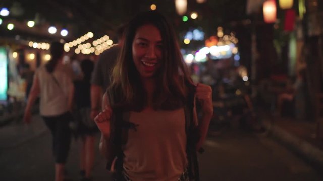 Slow motion - Young Asian traveling women backpacker drinking alcohol or beer and dancing in urban street night party at The Khao San Road in Bangkok, Thailand. Traveler and tourist concept.