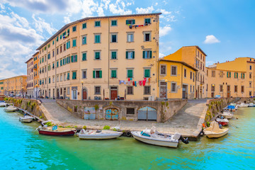 City view with colorful buildings and moored boats on canal in Venezia Nuova district of Livorno,...