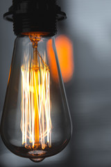 A classic Edison light bulb on dark background with space for text