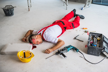 An unconscious man worker lying on the floor after accident on the construction site.