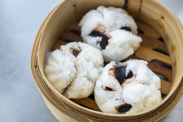 Steamed Black Bean Bun in a Bamboo Dish on the Table © thaiprayboy