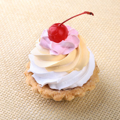 Tasty Homemade cupcake, muffin with cream and cherry. Close up view delicious sweet dessert isolated on white.