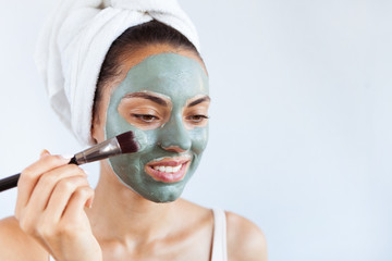 Young beautiful woman in face mask of therapeutic blue mud. Spa treatment, self care and healthy skin