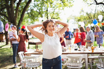 A teenage girl on a family celebration or a garden party outside.