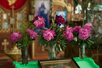 Fototapeta na wymiar Church altar decorated with chrysanthemums. Interior of a village orthodox church