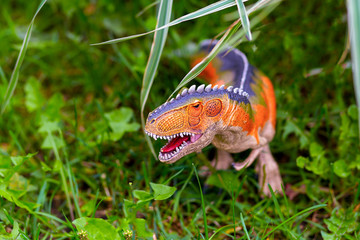 A predatory dinosaur with huge teeth in the jungle. A figurine of a dinosaur