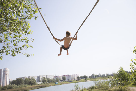 A child is riding on a rope village swing