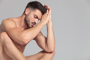 naked fit young man lies down and meditates