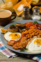 Full English breakfast, with sausage, mushrooms, beans and a fried egg.