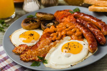 Full English breakfast, with sausage, mushrooms, beans and a fried egg.
