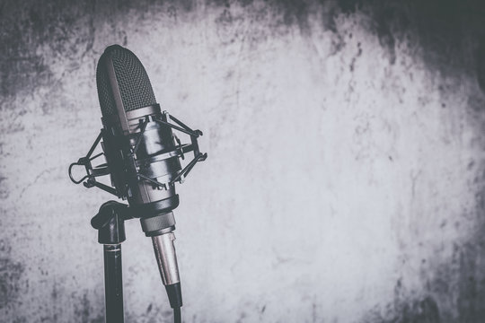 old black and white condenser microphone on wall background with copy space