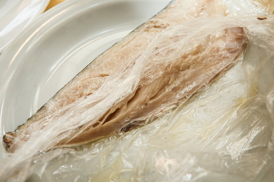 one part of raw mackerel fillet lie in food film