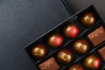 Set of luxury handmade bonbons in box on black background