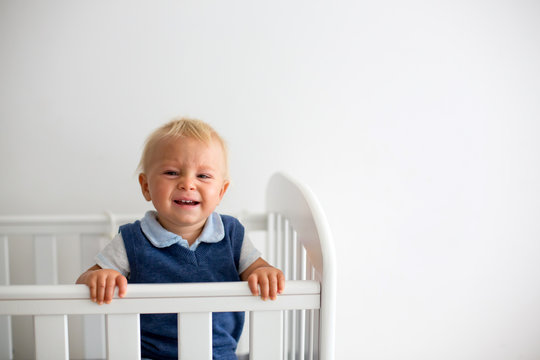 Sad Little Baby Boy, Nicely Dressed, Feeling Unhappy In Baby Cot