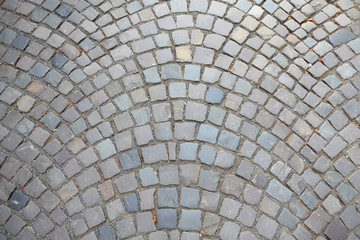 Stone pavement texture, granite cobblestoned pavement background, cobbled stone road regular shapes, abstract background of old cobblestone pavement close-up