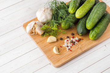 Marinated cucumbers, garlic and spices for salting on the wood surface.