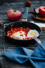 Shakshuka, Fried Eggs with Tomato Sauce in a Pan, Rustic Style and Wooden Background