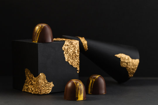 Luxury bonbons painted with gold on black background