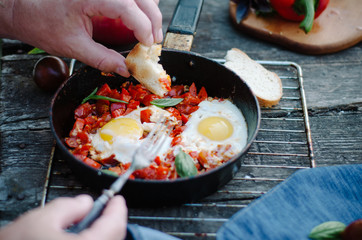 Shakshuka, Fried Eggs with Tomato Sauce in a Pan, Rustic Style and Wooden Background