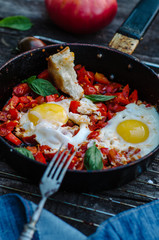 Shakshuka, Fried Eggs with Tomato Sauce in a Pan, Rustic Style and Wooden Background