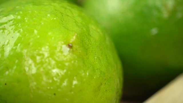 Lime crust with Water Drops. Macro shooting of a citrus. Green juicy lime. dolly shot, sliding camera move, 4K
