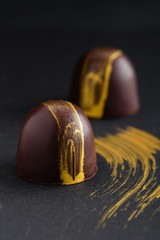 Luxury bonbons painted with gold on black background