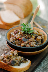 Traditional Caucasian saute from stewed eggplants, peppers, onions, tomatoes and herbs on the old background in rustic style