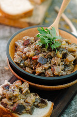 Traditional Caucasian saute from stewed eggplants, peppers, onions, tomatoes and herbs on the old background in rustic style